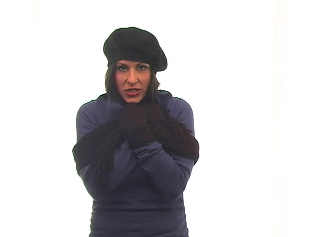 A beautiful young woman with a radiant smile in winter wardrobe against a white background.