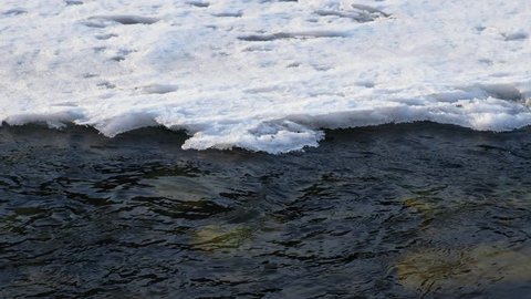 Video of closeup mooving along tracery edge of an ice floe on Altai river Katun in Spring season. Stones on the bottom under water. Siberia, Russia