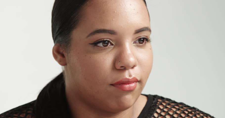 Sitting large curvy African American girl wearing a black fishnet top isolated on white. ideal skin, pretty smile portrait