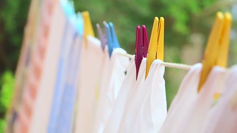 Drying laundry on the clothesline close up. Clean laundry hanging on a clothesline. Clean washed laundry hooked with clothespin hanging to the on clothesline