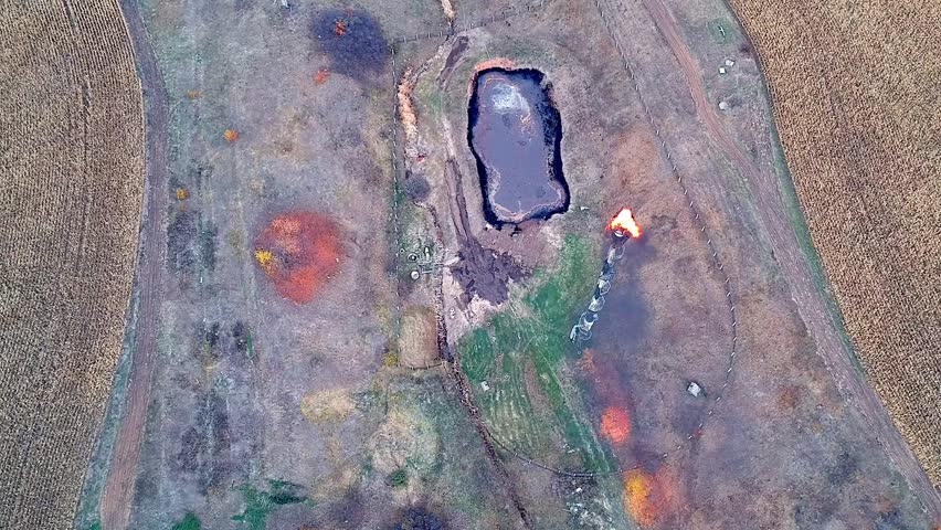 Aerial view on oil rig and pipe with flame at the autumn cloudy light.