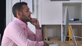 Mixed race man has video call conversation. Handsome businessman sitting at the desk looking on screen computer talking with client or friend using internet for online negotiation. Entrepreneur use