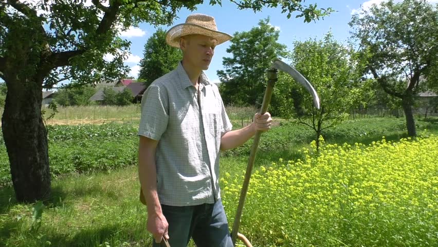 The man is sharpening a blade of a spit for easy mowing.