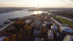 Russia, Saint-Petersburg,  Aerial video of Peter and Paul fortress at sunset, walls of fortress, Golden autumn, panorama landscape, sunny day, golden spire with cross and angel, drawbridges, hermitage
