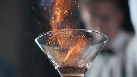 Bartender sets fire to cocktail, burning cinnamon in alcohol drink, 240 frames per second, barman makes drink