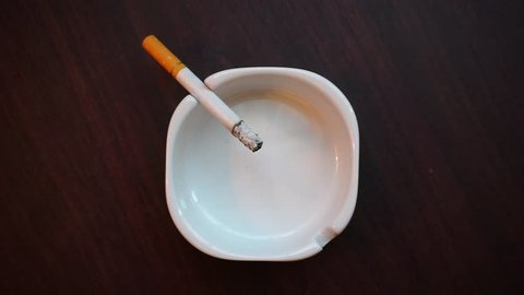 Footage: Close Up of cigarette on ashtray in top view. Smoking harms health. Stop smoking concept.