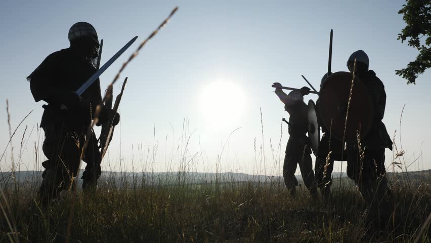 Silhouettes of Vikings warriors fighting with swords, shields. Contre-jour Royalty-Free Stock Footage #32014507