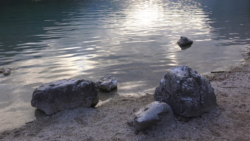 Rocks at lake shore. Footage is taken in sunset on banks of Lake Bohinj in Slovenia.
