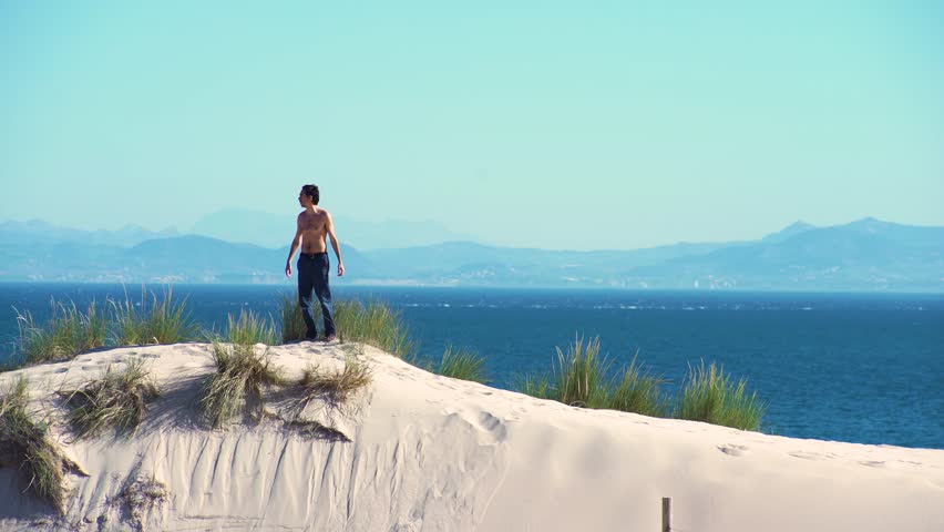 Young man exercising in a dune sand