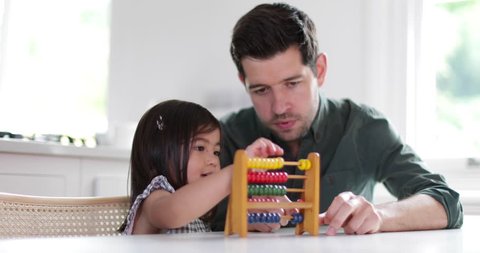 Girl using abacus to count with Father