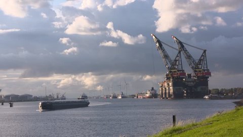 EUROPOORT, PORT OF ROTTERDAM - AUGUST 2017: marine traffic on Calandkanaal + Thialf maintenance platform, the largest deepwater construction vessel (DCV) moored at home port.