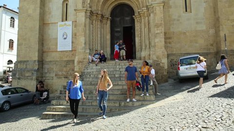 Coimbra, Portugal - August 14, 2017: tourists in front of Old Coimbra Cathedral. Se Velha de Coimbra, is one of most important romanesque buildings in Central Portugal in university town of Coimbra.