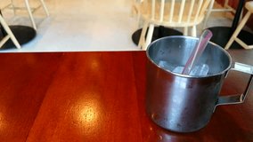 Pouring Pure Water into Stainless Steel Cup with Ice and Plastic Straw setting on the Wooden Table in the Restaurant Asian Concept, Objects Background with Copy Space 4K Video Footage Clip