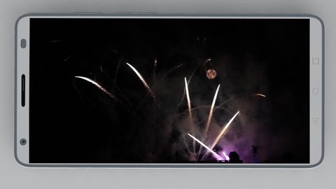 White smartphone with fireworks on the screen on white background