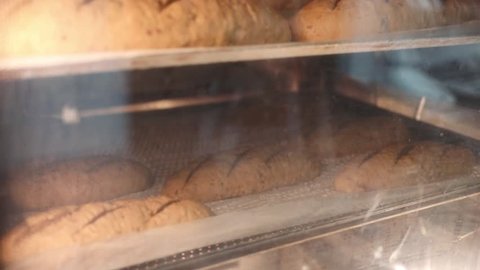 Few loaves of bread in the oven in the bakery, slow motion