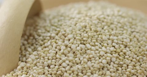 2k Super macro close up spoonful of quinoa grains tumbling into bowls