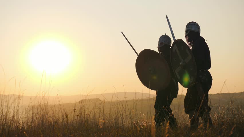 Silhouettes of Vikings warriors fighting with swords, shields. Contre-jour Royalty-Free Stock Footage #32043973