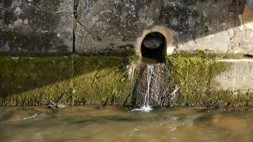 Water stream in front of an old texture brick wall