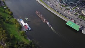 4K aerial high quality aerial video of Moscow City area, International business center, Moscow River road bridge and boats sailing with load along the river in Russia on busy autumn September day