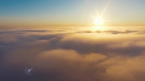 Aerial View. Flying in fog, fly in mist. Aerial camera shot. Flight above the clouds towards the sun. Misty weather, view from above. Birds point of view