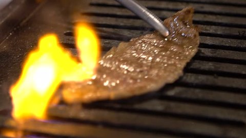 Slow motion delicious sliced beef grill on hot coal. Japan food in a restaurant barbecue. A Japanese BBQ Yakiniku style roast meat grilling-Dan