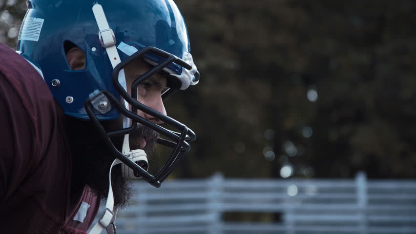 Side view close-up of the head of a determined American football player wearing protective blue helmet during match