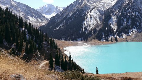 Tilt up of the emerald Big Almaty Lake in autumn season.