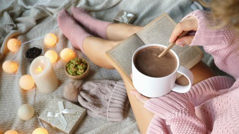 Hipster Girl Reading Book With Hot Drink In Comfortable Cozy Sweater. 4K. 