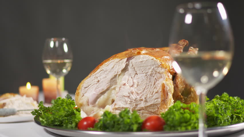 Thanksgiving whole roasted turkey garnished with tomatoes and herbs