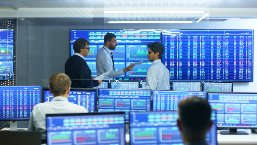 Three Experienced Stock Traders Talking Business, Consulting Documents and Argue About Data. They Work for a Big Stock Exchange Firm. Office is Full of Displays Showing Infographics and Numbers. | Shutterstock HD Video #32060707