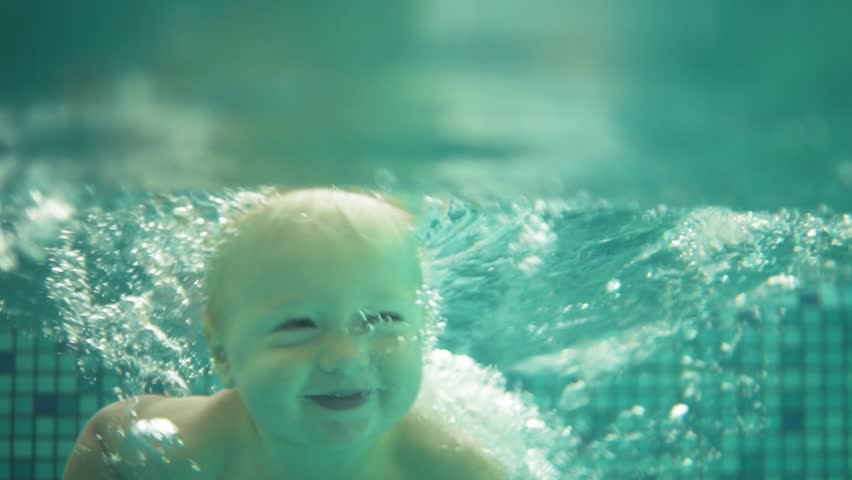 Happy smiling toddler is jumping and diving under the water in the swimming pool. An underwater shot. Slowmotion | Shutterstock HD Video #32065255