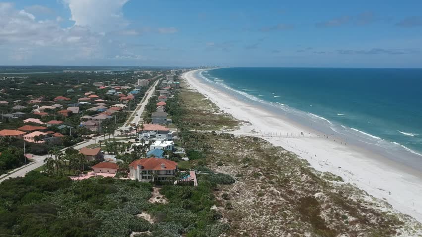 Beautiful aerial bird eye view of ocean waves crushing against the coast line of Daytona Beach, Florida.