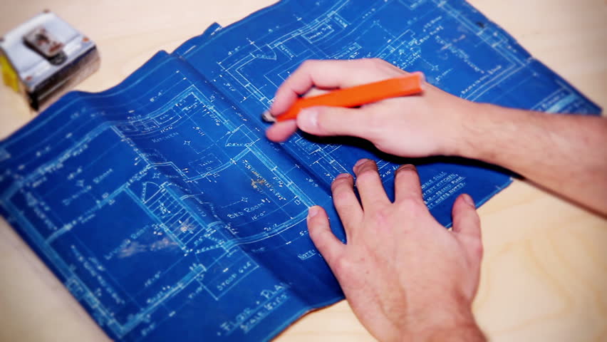 A carpenter examines a house's blueprints.