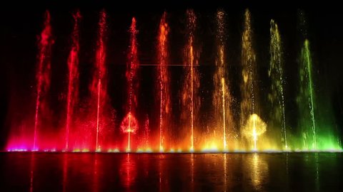 Dancing fountain show with reflection. Wide shot.