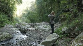Cliffs and forest in Eastern Serbia 4K 2160p 30fps UltraHD footage - Female hiker takes pictures under natural stone bridge 3840X2160 UHD video