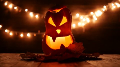 Carved Halloween pumpkin with lights on background. Dark key footage in UltraHd resolution.