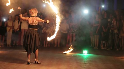 KIEV, UKRAINE - SEPTEMBER 2017 Amazing fireshow by young woman and man on a street in a night city..