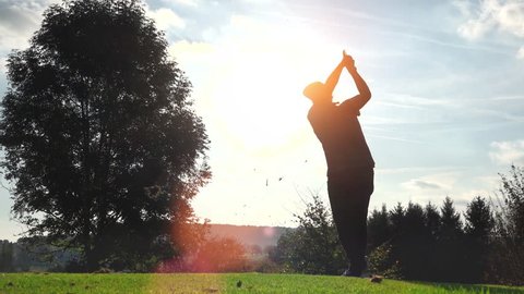 Golf Player plays golf on a beautiful summer morning. wide angle Lens flare Back lite shot - slow motion