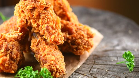 Crispy fried chicken wings and legs on a wooden table rotation 360 degrees. Breaded Crispy fried chicken tasty dinner. 4K UHD video footage. Ultra high definition 3840X2160