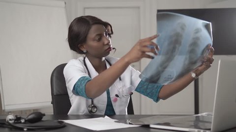 beautiful african american healthcare worker with x-ray, medical international concept, black doctor thinking, modern student research pneumonia coronavirus covid 19 pandemic quarantine วิดีโอสต็อก