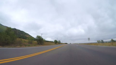 Colorado, USA - September 23, 2017 -  Driving POV in rural area of Western Colorado on cloudy day.