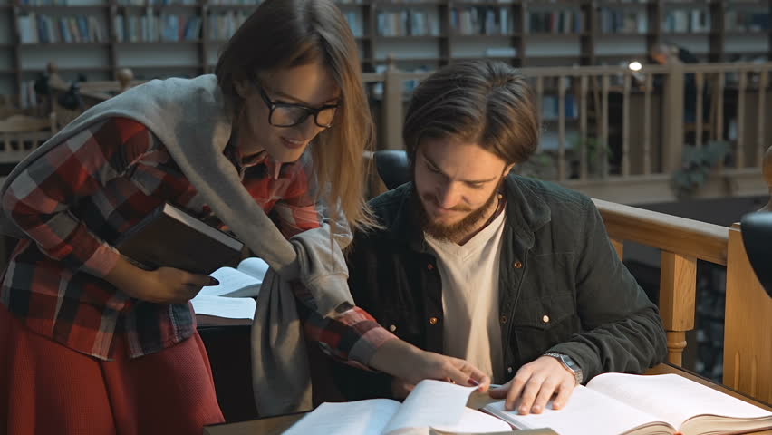 Casual stylish students have a study discussion in library  Royalty-Free Stock Footage #32137273