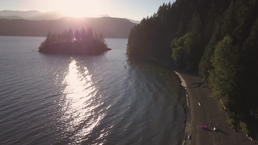 Aerial view of Harrison Lake during a vibrant and colorful summer sunset. Video taken East of Vancouver, British Columbia, Canada.