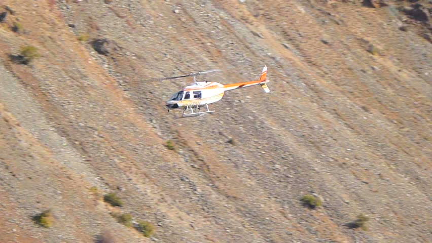 Low flying helicopter traveling through Snake River in Hell's Canyon.