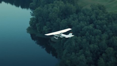 Aircraft flies over the forest and the river