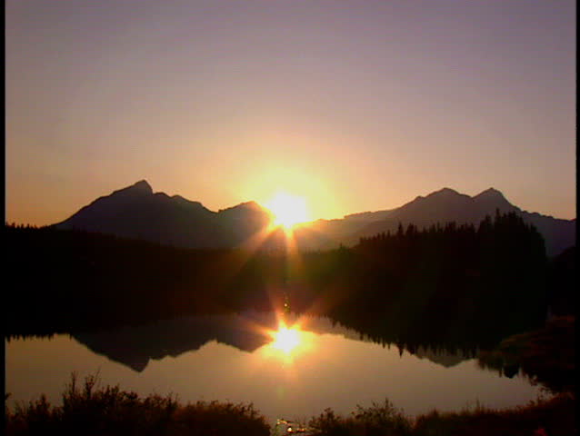 Wide shot of alpine lake at sunset