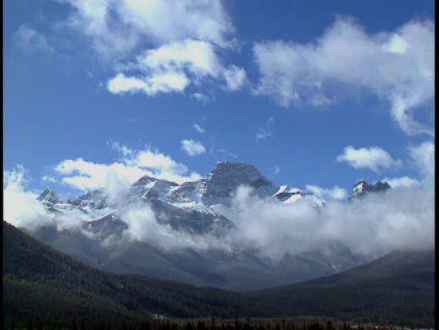 Clouds pass over winter mountain range in Kananaskis Alberta Canada