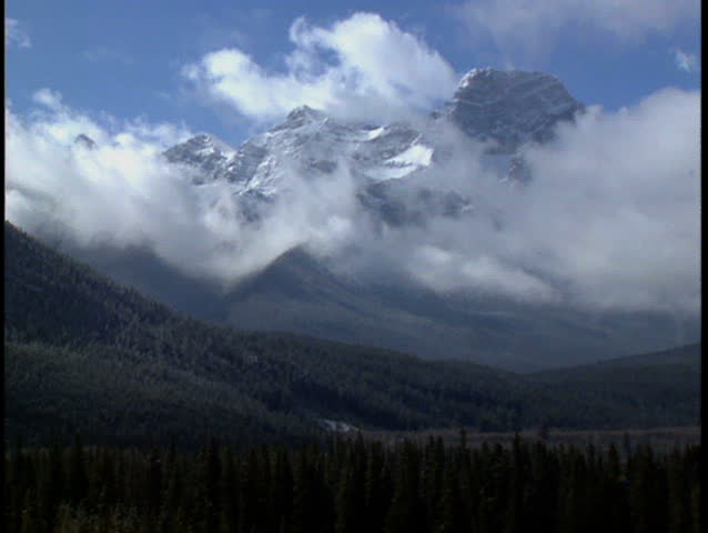Clouds pass over winter mountain range in Kananaskis Alberta Canada