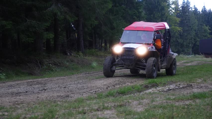 Buggy at a speed rides through a puddle of mud in a slow motion video 180fps