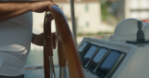 Close-up Side View Shot of a Skipper's Hands Holding Sailing Yacht's Steering Wheel. Dashboard Shows Knots, Degrees and Wind Direction. Calm Sea in the Background. Shot on RED Epic 4K UHD Camera.